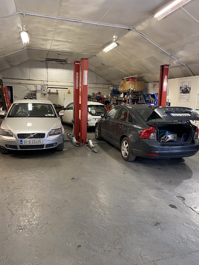 Inside the workshop — two red Phoenix lifts, a couple of cars on the floor, no people